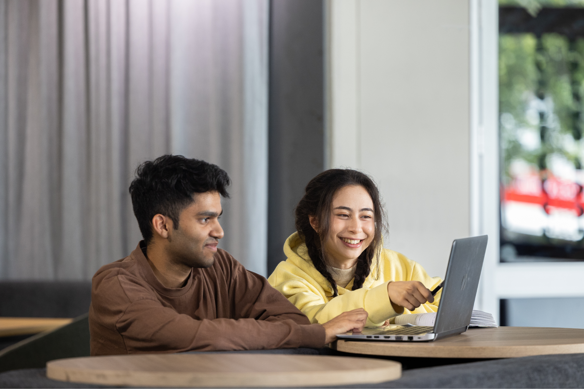 two-students-smiling-at-laptop-screen